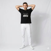 Man wearing a black t-shirt with white text and graphics against a plain background