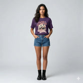Woman wearing a purple graphic t-shirt and denim shorts on a white background