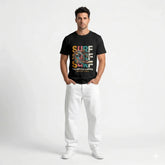 Black t-shirt with colorful 'Surf The Endless Summer' design on a hanger against a white wall.