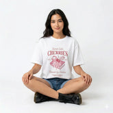 Woman wearing a white t-shirt with a graphic design on a gray background
