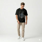 Man wearing a black t-shirt with 'Enigma' design on a white background