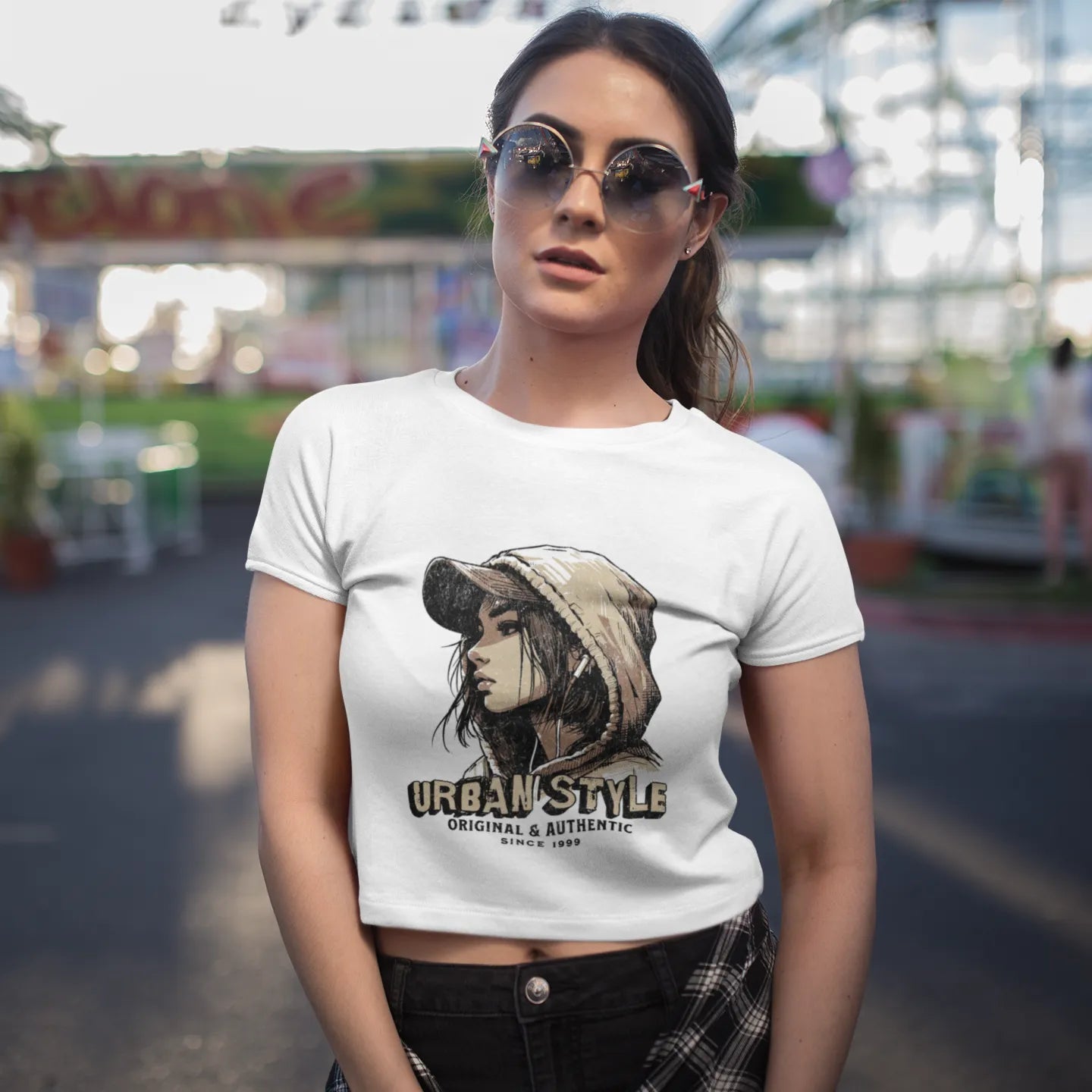 Woman wearing a white t-shirt with a graphic design at an amusement park.