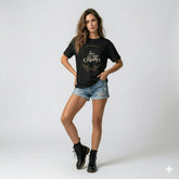 Woman wearing a black t-shirt with text and denim shorts on a white background