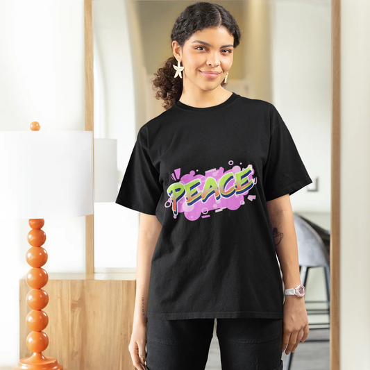 Person wearing a black t-shirt with colorful text, standing in a room.