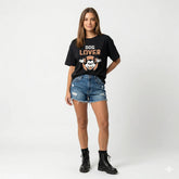 Woman wearing a black 'DOG LOVER' t-shirt with denim shorts on a white background