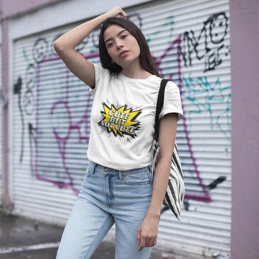 Woman wearing a white t-shirt with a graphic design in front of a graffiti-covered wall.