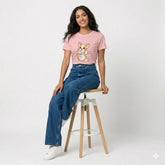 Woman wearing a pink t-shirt with a dog graphic, standing outdoors.