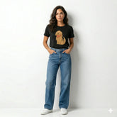 Woman wearing a black t-shirt with a dog graphic and blue jeans on a white background