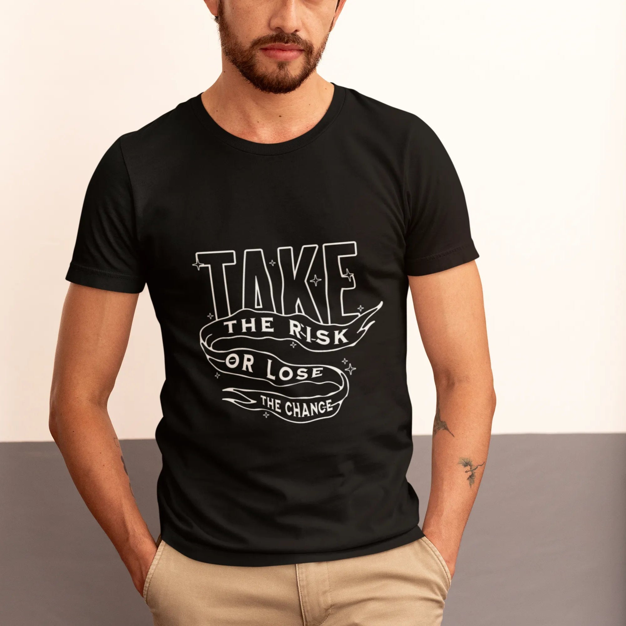 Man wearing a black t-shirt with motivational quote, standing against a neutral background.