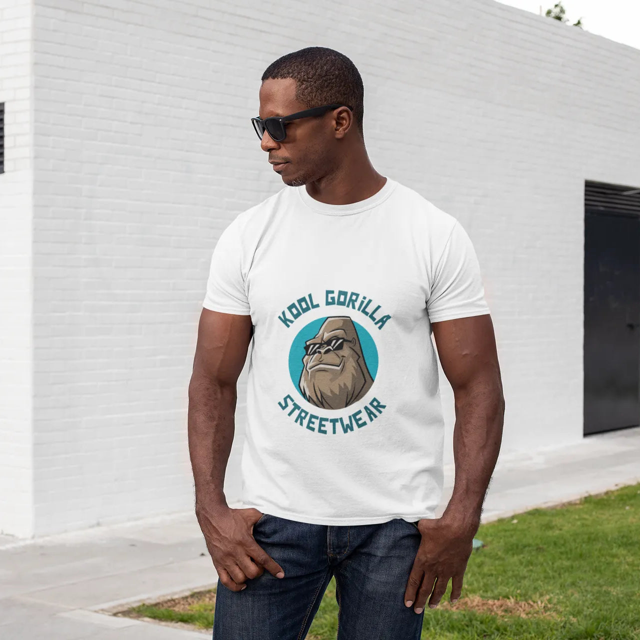 Man wearing a white t-shirt with a graphic design standing in front of a white building.