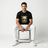 Man sitting on a chair wearing a black t-shirt with 'Drink Drink Drink' text and a beer graphic.