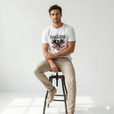 Man sitting on a stool wearing a white t-shirt with a graphic design and text.