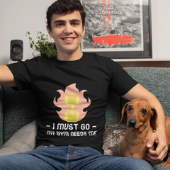 Man sitting on a couch with a dog, wearing a black t-shirt with a graphic design and text.