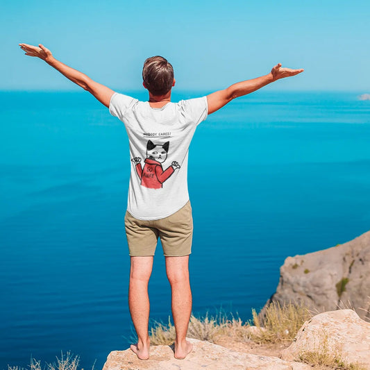 Person standing on a cliff overlooking a blue sea with arms outstretched