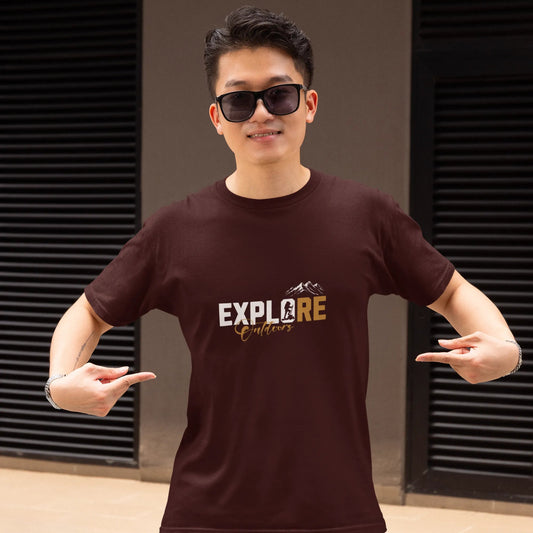 Person wearing a brown t-shirt with 'EXPLORE' printed on it, standing against a neutral background.