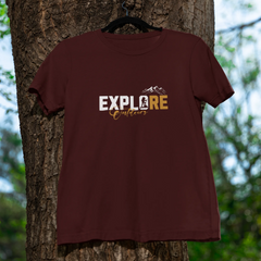 Brown t-shirt with 'EXPLORE' printed on it hanging on a tree