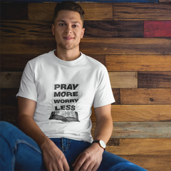 Person wearing a white t-shirt with text sitting against a wooden wall.