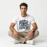 Man wearing a white t-shirt with text sitting cross-legged on a light background