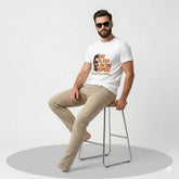 Man sitting on a stool wearing a white t-shirt with text and graphics.