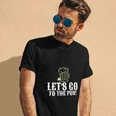 Man wearing a black t-shirt with 'Let's Go to the Pub!' text and graphic on a beige background