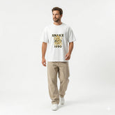 Person wearing a white t-shirt with gold text outdoors