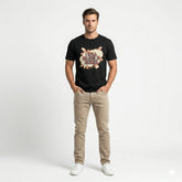 Man wearing a black t-shirt with a graphic design and text, beige pants, and white shoes on a white background