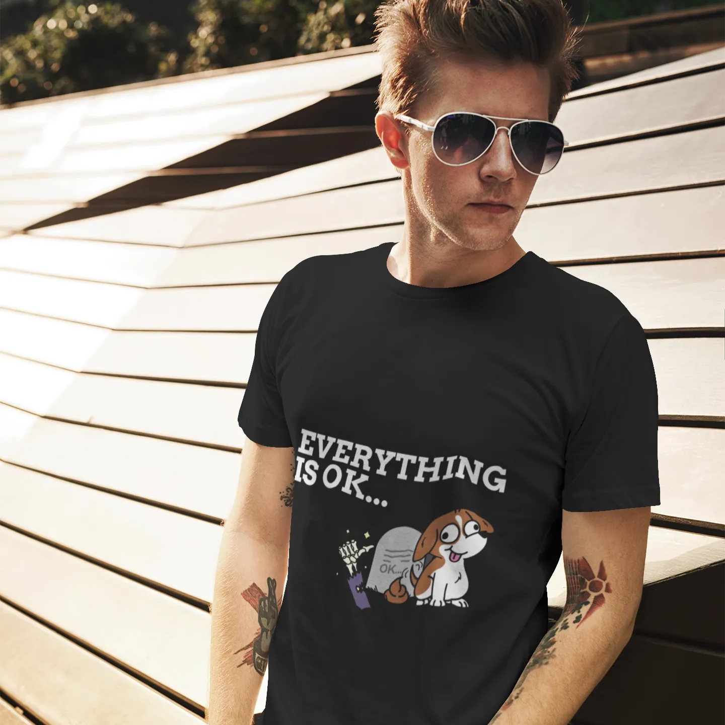 Person wearing a black t-shirt with a graphic and text, standing outdoors.