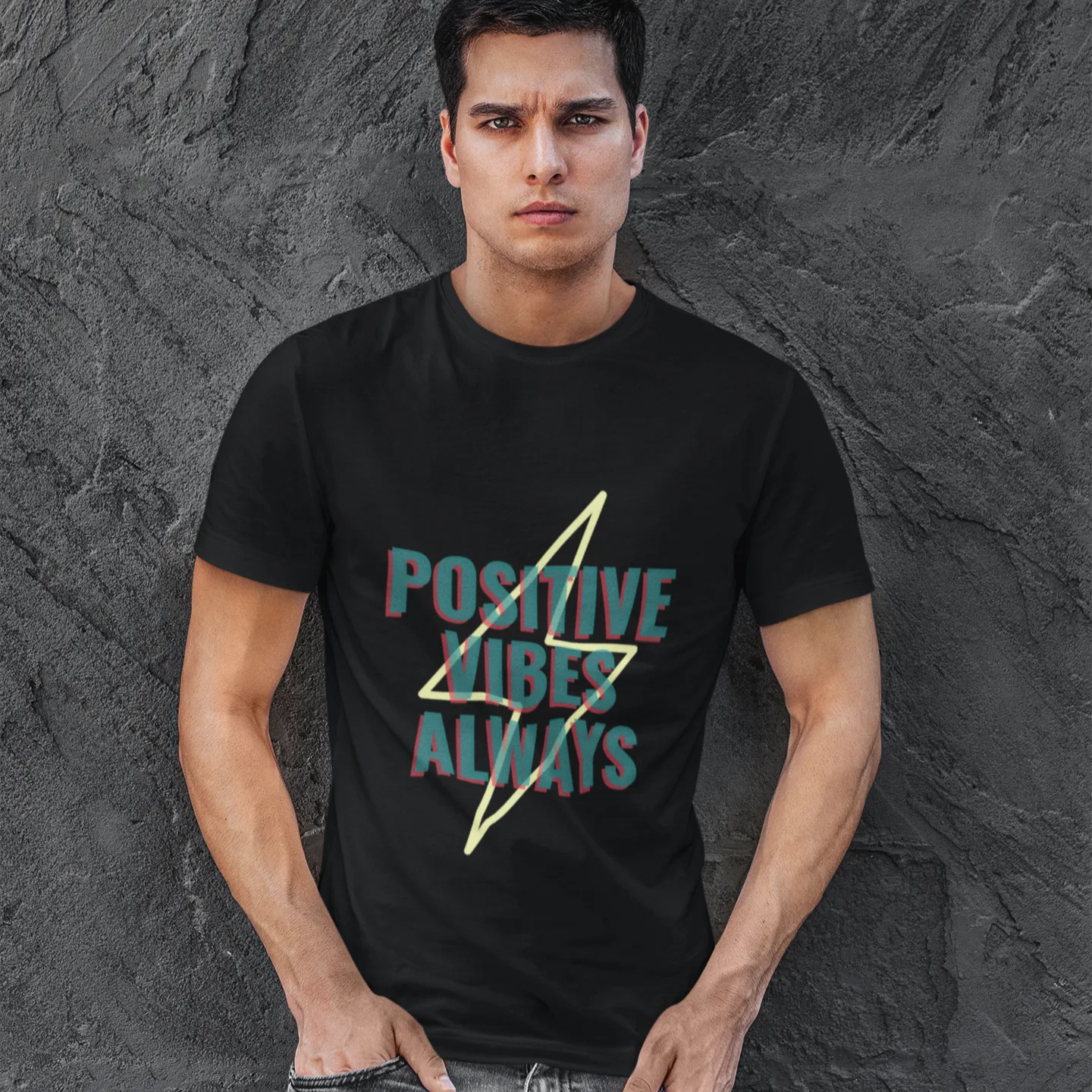 Man wearing a black t-shirt with 'Positive Vibes Always' text against a textured gray background