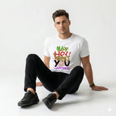 Man wearing a white t-shirt with colorful text design sitting on a white background