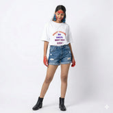 Person wearing a white t-shirt with text and blue denim shorts on a white background