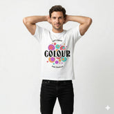 Man wearing a white t-shirt with colorful text and design on a plain background