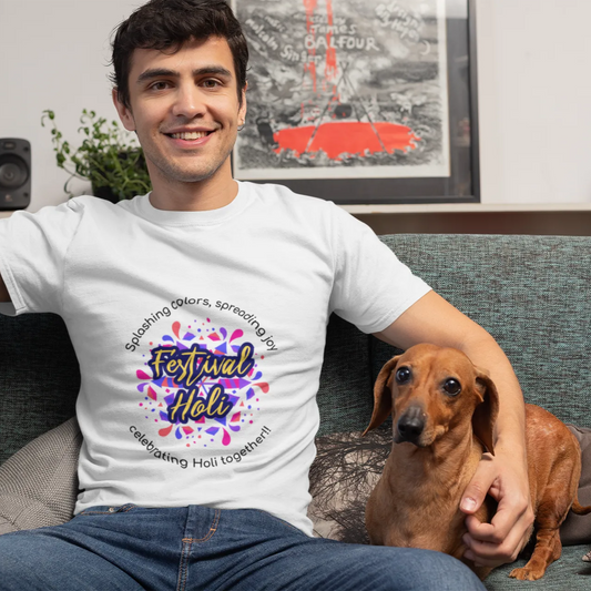 Man wearing a white t-shirt with a colorful design, sitting on a couch with a dog.