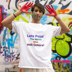 Person with painted hands and colorful face standing in front of a graffiti wall wearing a t-shirt with a message about using Holi colors.