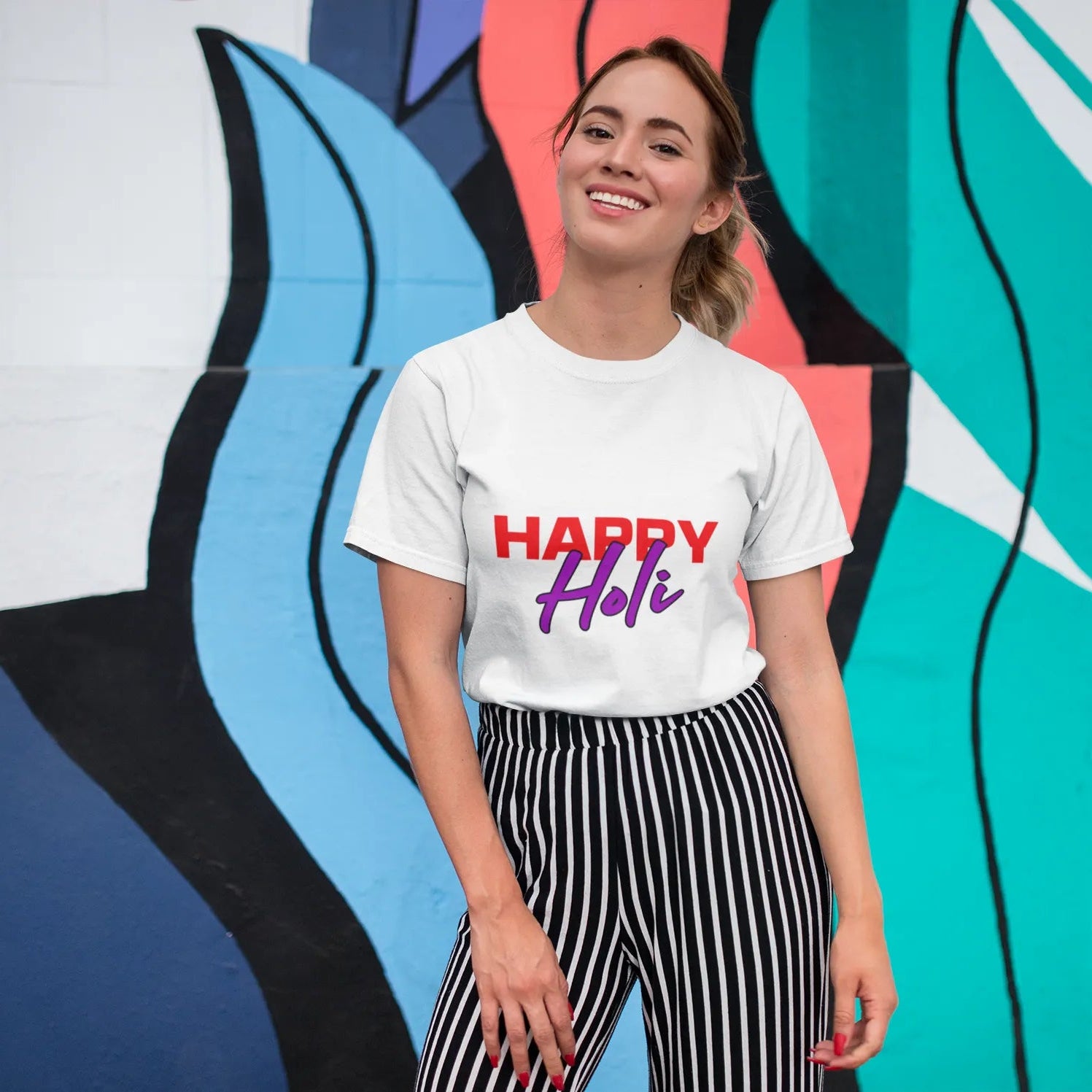 Person wearing a white t-shirt with 'Happy Hi!' text in front of a colorful mural.