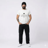 Man wearing a white t-shirt with text and black pants on a white background