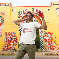 Person posing in front of a colorful mural with vibrant graphics and text.