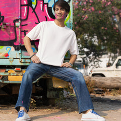 Person sitting on a graffiti-covered truck with trees in the background