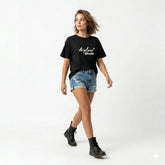 Woman wearing a black t-shirt with 'Airplane Mode' text and denim shorts on a white background