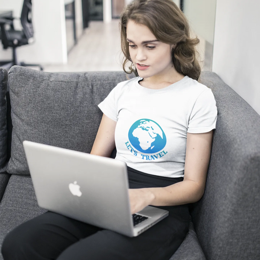 Person using a laptop on a gray couch in a modern office setting