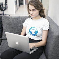 Person using a laptop on a gray couch in a modern office setting