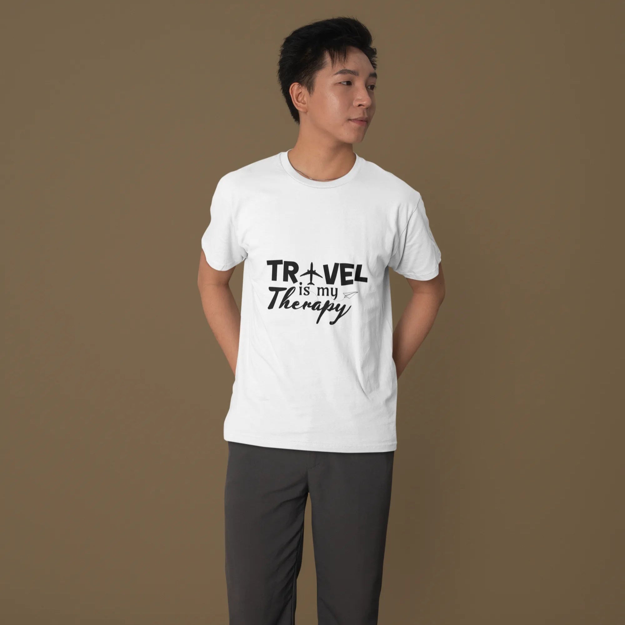 Person wearing a white t-shirt with 'Travel is my Therapy' text on a brown background