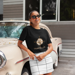 Woman wearing a black t-shirt with 'World Traveller' design in front of a vintage car.
