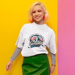 Person wearing a white sweatshirt with a graphic design on a yellow and pink background