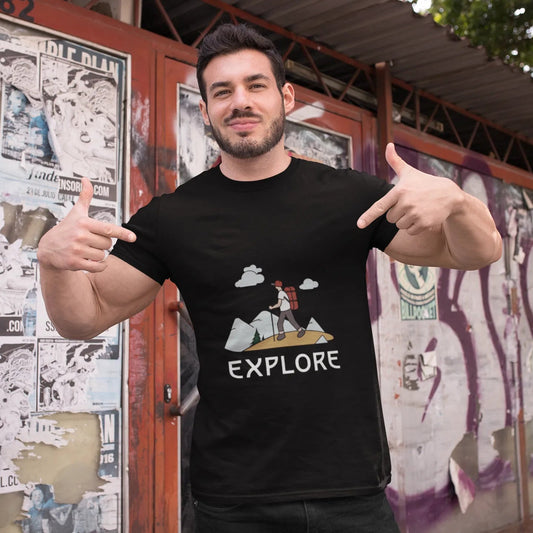 Man wearing a black t-shirt with 'EXPLORE' graphic design, giving a thumbs-up gesture in front of a colorful wall.
