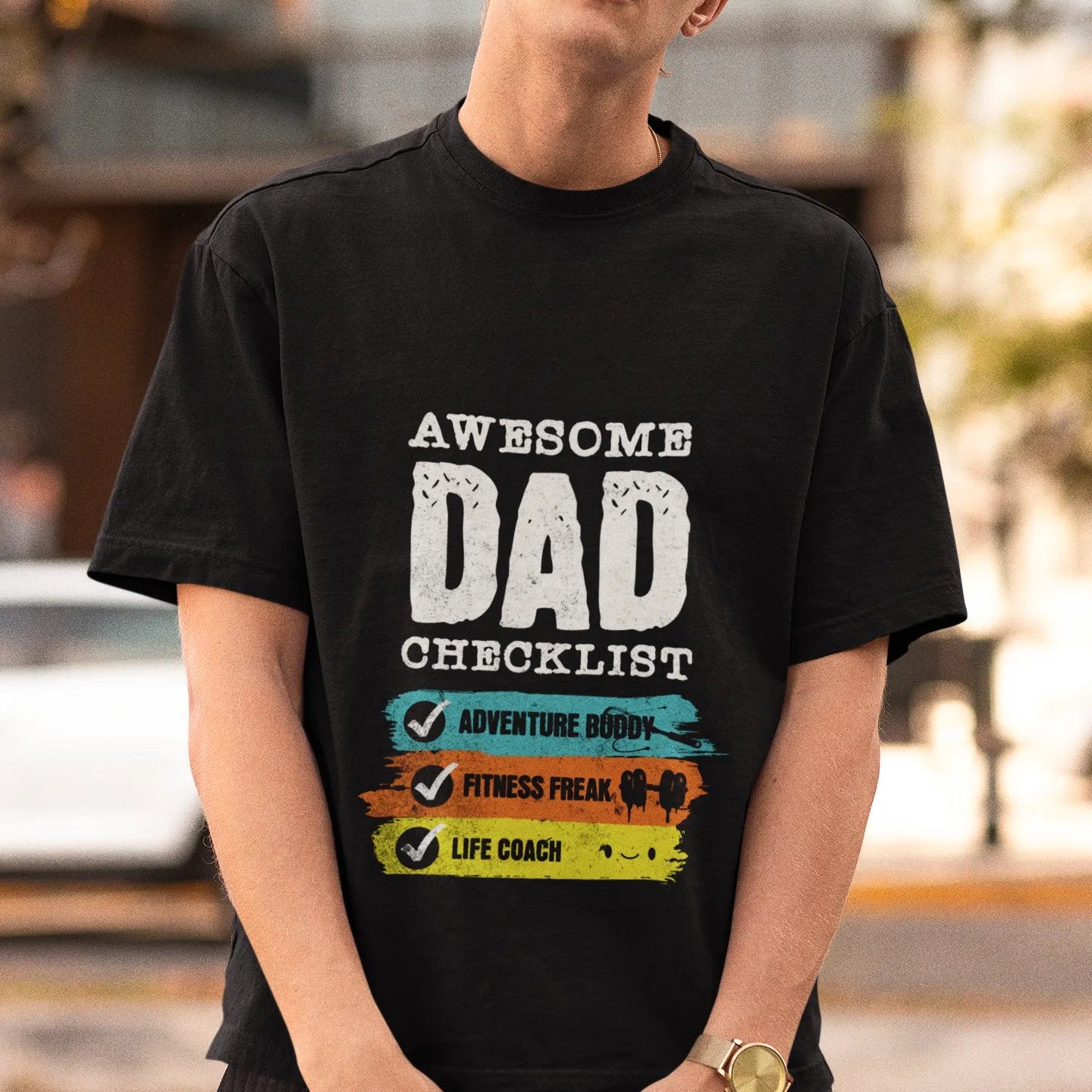 Man wearing a black t-shirt with 'Awesome Dad Checklist' text outdoors.
