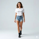 Woman wearing a white t-shirt with 'F.A.T.H.E.R.' text and denim shorts on a light gray background