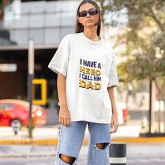 Person wearing a white t-shirt with text and ripped jeans on a street.