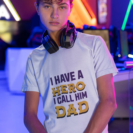Person wearing a t-shirt with 'I have a hero I call him Dad' text in a colorful, possibly gaming or electronic setting.