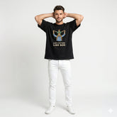 Man wearing a black t-shirt with a graphic and text, standing against a white background