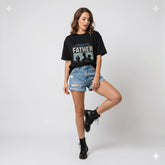 Woman wearing a black t-shirt with 'Best Father in the World' text and denim shorts on a white background